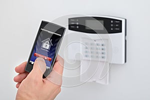 Security alarm keypad with person disarming the system photo