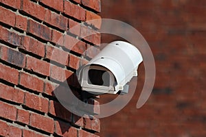 Security camera on brick wall facade