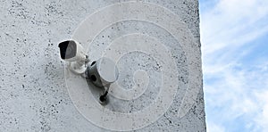 Security camera on concrete wall for surveillance and safety in urban settings