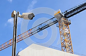 Security camera at the construction site with a tower crane