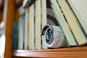 Security camera hidden among some books for surveillance of the interior of the home.