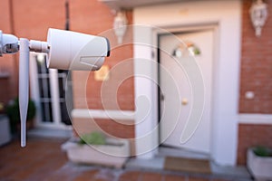 Security camera installed in the garden of a house for the surveillance of the entrance door to the house