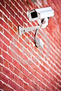 Security camera mounted on brick wall