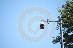 Security camera mounted on pole against clear blue sky
