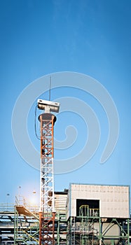 Security camera in petrochemical plant with blue sky background
