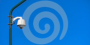 Security camera on a pole against blue background