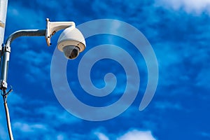 Security camera on a pole against blue sky background