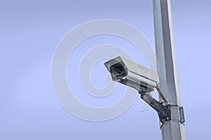 Security camera on a post over clear sky background
