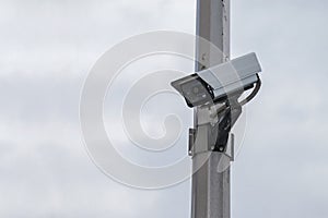 Security camera on a post over clear sky background