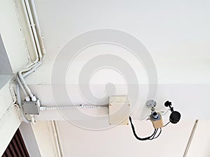 Security camera, surveillance camera or CCTV Close Circuit Television installed on white ceiling inside the building.