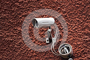 Security camera on red wall