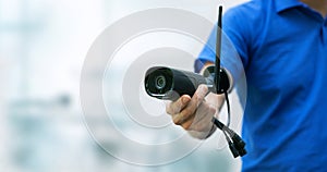 security cameras and cctv services background - man holding ip camera in hand