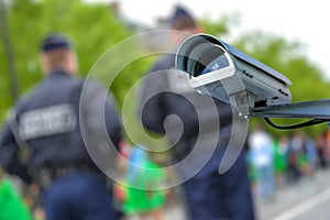 security CCTV camera or surveillance system with police officers on blurry background