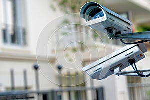 security CCTV camera or surveillance system with private builiding on blurry background photo