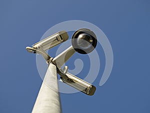 Security cctv cameras in front of blue sky
