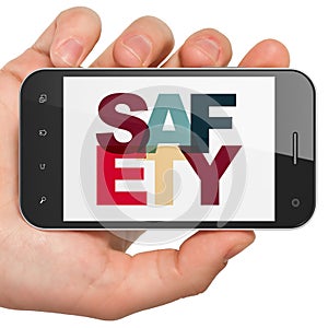 Security concept: Hand Holding Smartphone with Safety on display