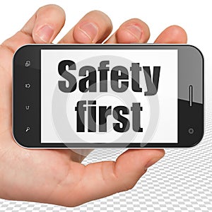 Security concept: Hand Holding Smartphone with Safety First on display