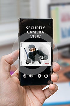 Security concept. Man holds smartphone with security camera view