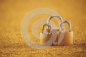 Security concept with three padlocks over golden background
