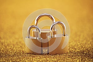 Security concept with three padlocks over golden background