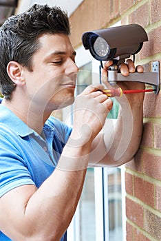 Security Consultant Fitting Camera To House Wall