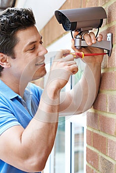 Security Consultant Fitting Security Camera To House Wall