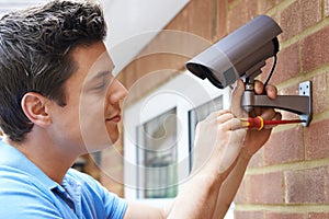 Security Consultant Fitting Security Camera To House Wall