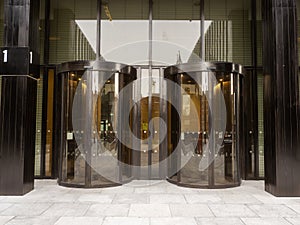 Security entrance to an office or residential building with spinning doors and brown glass. High value company property. Modern