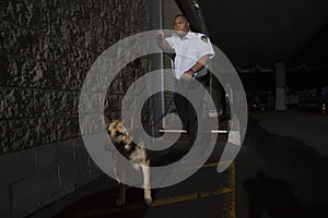 Security Guard In Alleyway Pursuit With Dog photo