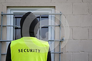 Security guard in front of the barred window