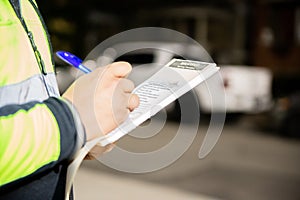 A security guard is giving a parking ticket to illegal parking on street of Toronto, Canada.