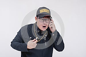 A security guard looking alarmed after advised by his colleague over the wireless radio about a suspicious intruder entering the