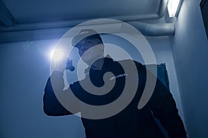 Security Guard Searching With Flashlight In Office