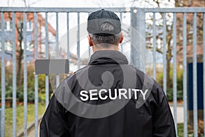 Security Guard Standing In Front Of Gate