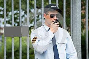 Security Guard Talking On Walkie-talkie