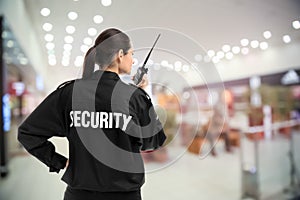 Security guard using portable radio transmitter in shopping mall