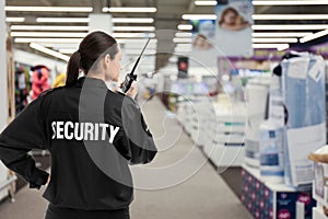 Security guard using portable radio transmitter in shopping mall