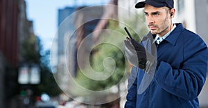 Security guard with walkie talkie against blurry street