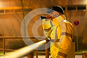 Security Guard Walking Building Perimeter With Flashlight