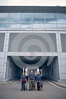 Security guards with detection dogs standing on the street