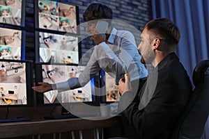 Security guards monitoring cameras indoors