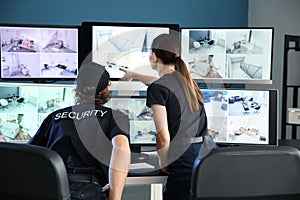 Security guards monitoring modern CCTV cameras in surveillance room