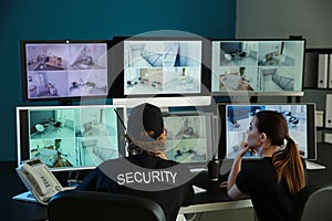 Security guards monitoring modern CCTV cameras in surveillance room