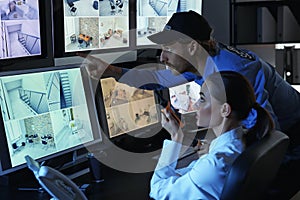 Security guards monitoring modern CCTV cameras in surveillance room photo