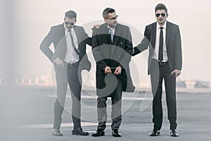 security guards standing with arrested man