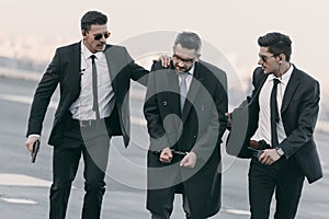 security guards with weapon standing with arrested man