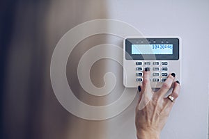 Security home system. Woman entering secret code on home alarm