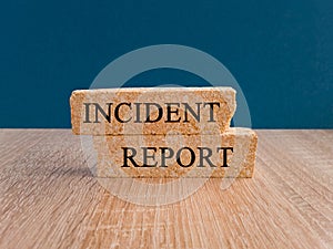 Security and insurance concept. Brick blocks with the inscription - Incident report on beautiful blue background, wooden table.