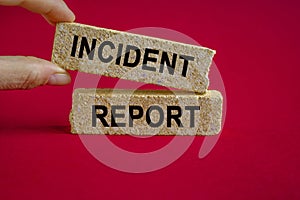 Security and insurance concept. Brick blocks with the inscription - Incident report on beautiful red background. Businessman hand