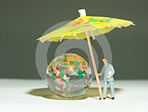 Security man holding umbrella under globe